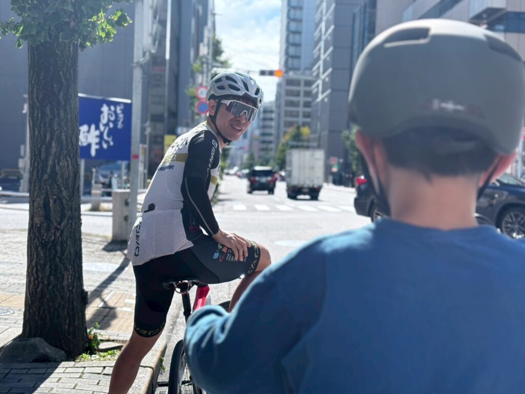 コーチと一緒に自転車の練習をする男の子